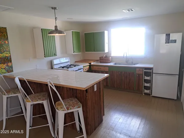 a kitchen with stainless steel appliances a table chairs and a refrigerator