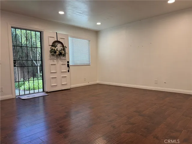 an empty room with windows and wooden floor