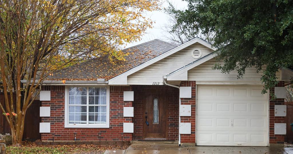 a front view of a house with a tree