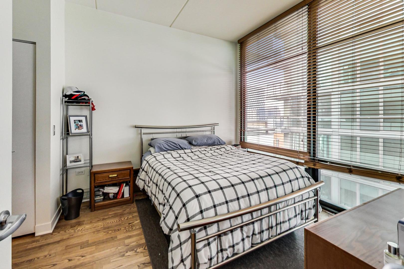 660 West Wayman Street, Unit 603 Chicago, IL 60661 - Photo 9 of 31 a bedroom with a bed and wooden floor