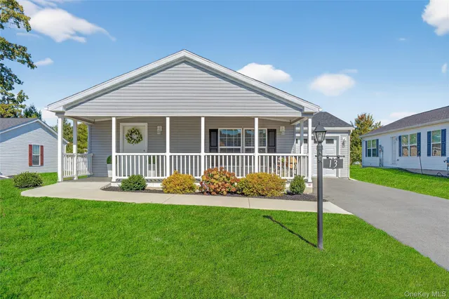 a front view of house with a yard and green space