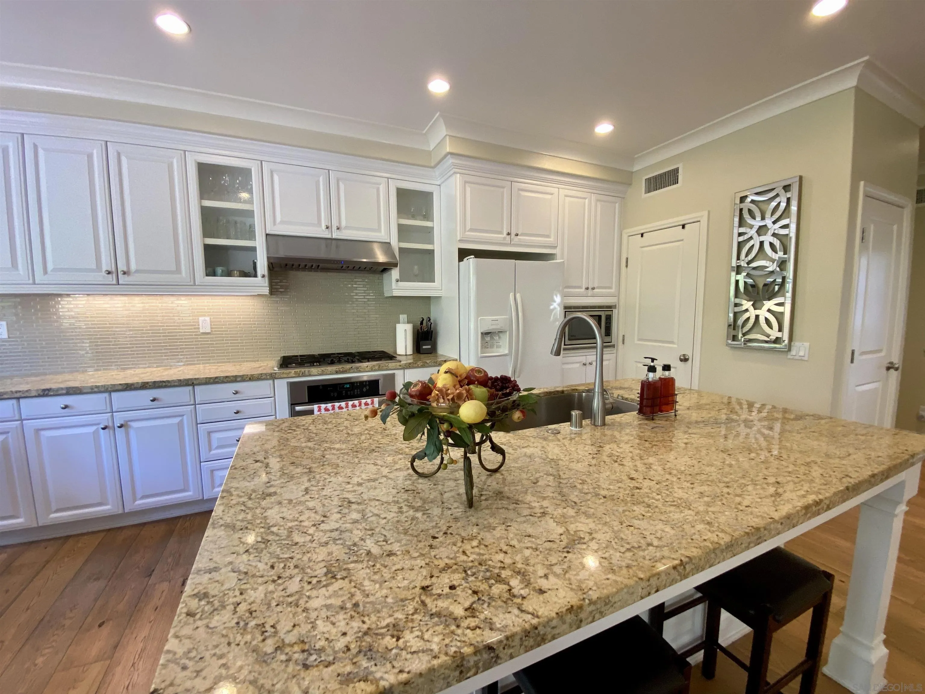 45 Diamond Irvine, CA 92620 - Photo 8 of 16 a kitchen with kitchen island granite countertop a stove a refrigerator a sink a dining table and chairs