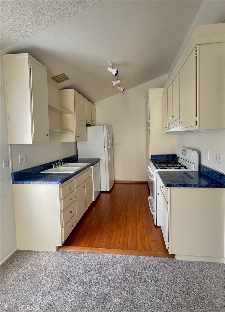 1350 Cabrillo Park Drive, Unit F Santa Ana, CA 92701 - Photo 11 of 32 a kitchen with wooden floors and white appliances