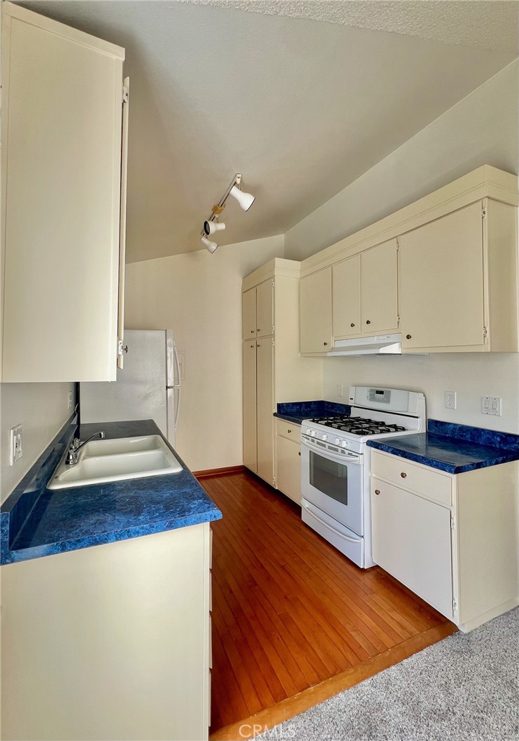 1350 Cabrillo Park Drive, Unit F Santa Ana, CA 92701 - Photo 12 of 32 a kitchen with sink window and cabinets