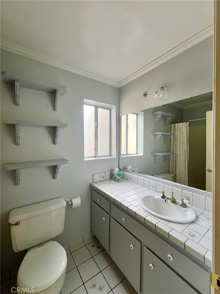 1350 Cabrillo Park Drive, Unit F Santa Ana, CA 92701 - Photo 19 of 32 a bathroom with a granite countertop toilet sink and mirror