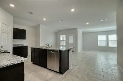 a large kitchen with kitchen island granite countertop a sink and a stove top oven