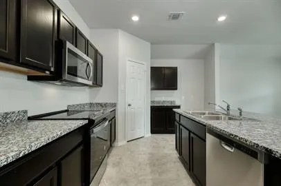 a kitchen with stainless steel appliances granite countertop a sink stove and microwave