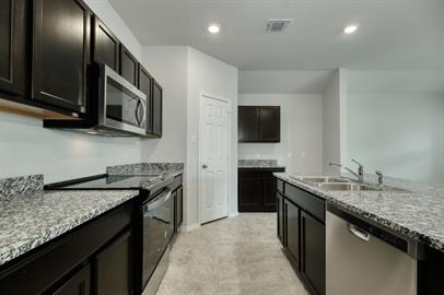720 Taggart Trail Jarrell, TX 76537 - Photo 3 of 12 a kitchen with stainless steel appliances granite countertop a sink stove and microwave