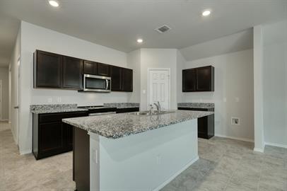 720 Taggart Trail Jarrell, TX 76537 - Photo 5 of 12 a kitchen with a granite counter tops and a stove