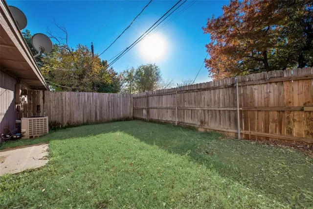 a view of backyard with wooden fence and trees