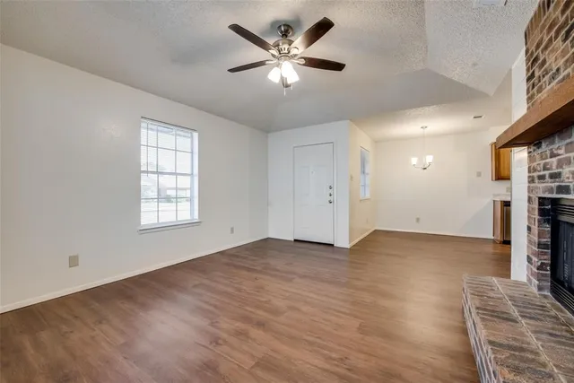 an empty room with windows and a ceiling fan
