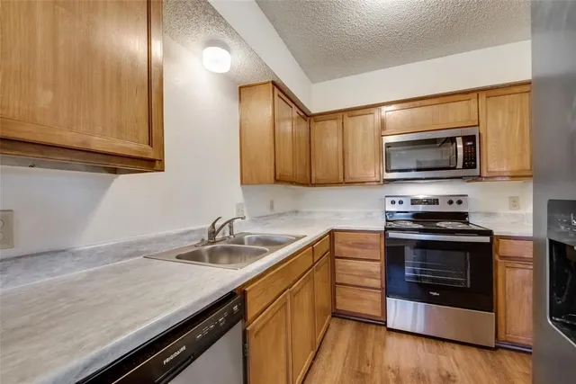 a kitchen with stainless steel appliances a stove microwave and sink