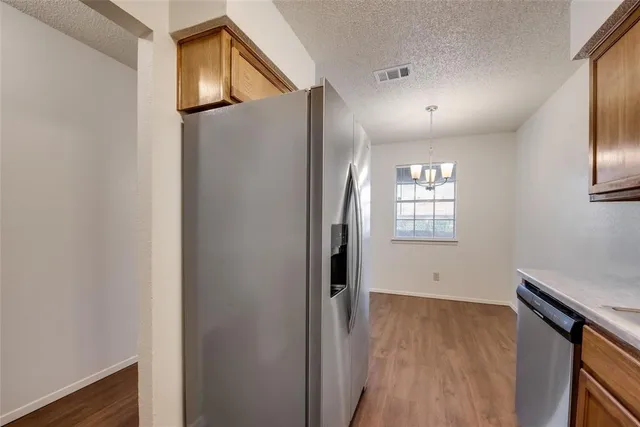 a view of hallway with wooden floor and cabinet