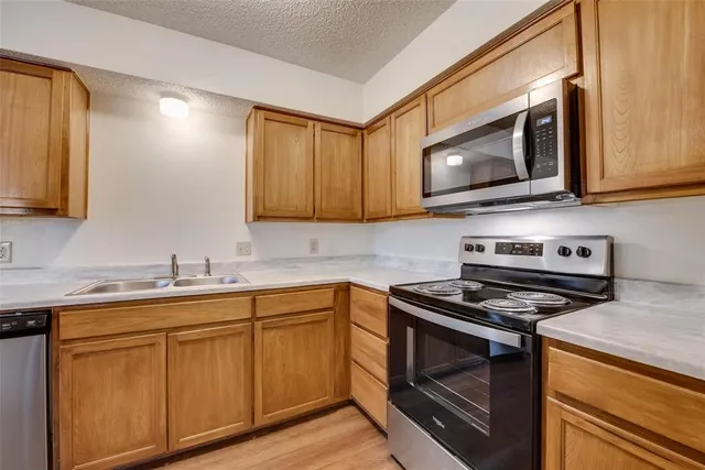 a kitchen with cabinets stove and microwave