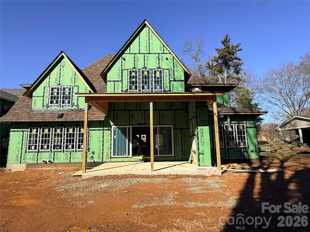 a view of a brick house with large windows and a small yard