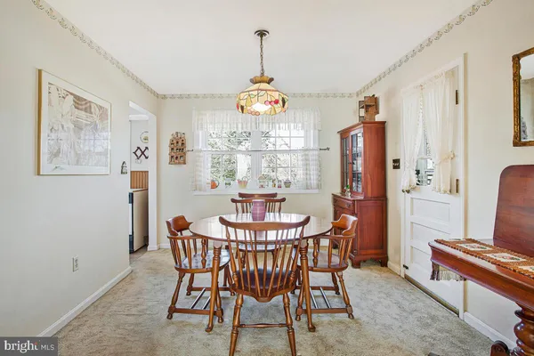 a dining room with furniture a chandelier and window