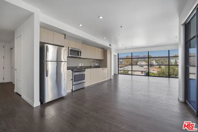 a view of a kitchen with wooden floor and a refrigerator