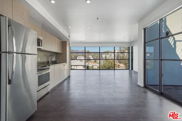 a kitchen with stainless steel appliances a refrigerator and wooden floor