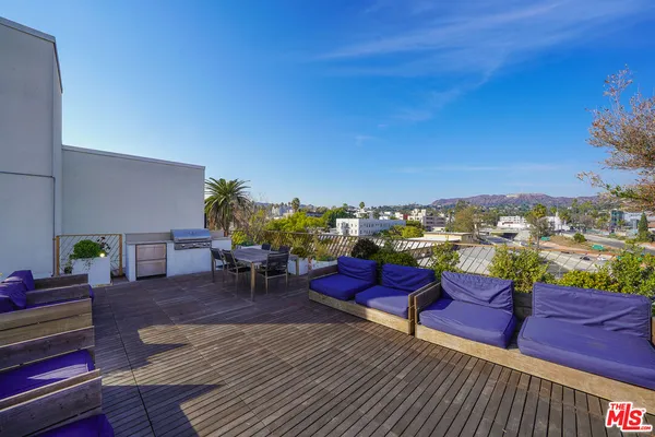 a view of a rooftop deck with couch and chairs