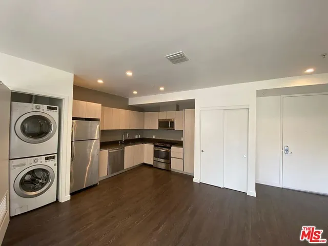 a kitchen with a refrigerator and a stove top oven