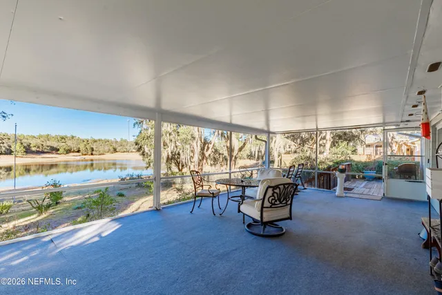 a living room with patio furniture and a large window