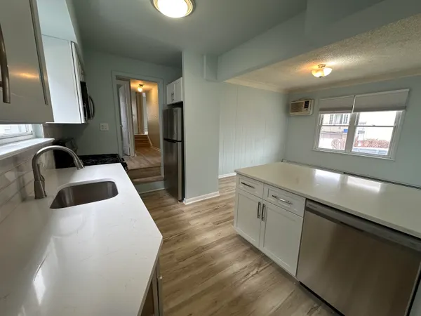 a kitchen with granite countertop a sink and a refrigerator