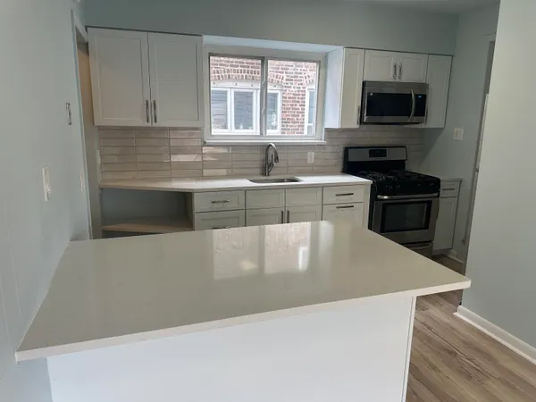 a kitchen with stainless steel appliances a stove microwave and sink