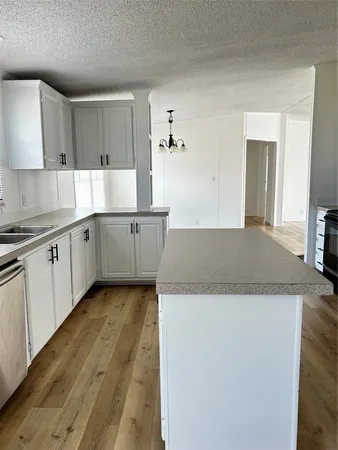 a kitchen with granite countertop a sink and white cabinets