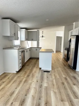 a kitchen with granite countertop a refrigerator stove top oven and sink