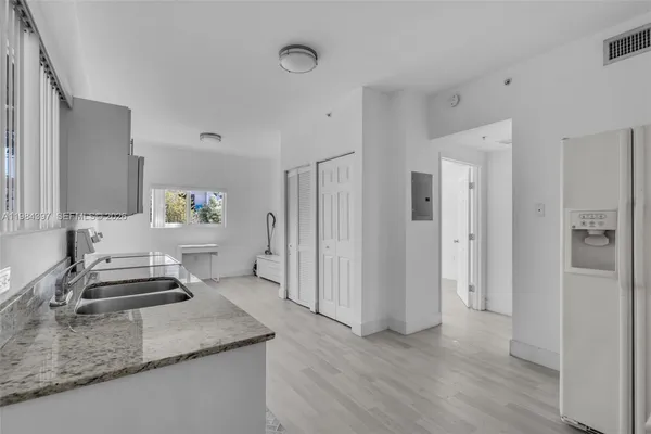 a kitchen with stainless steel appliances granite countertop a refrigerator and a sink