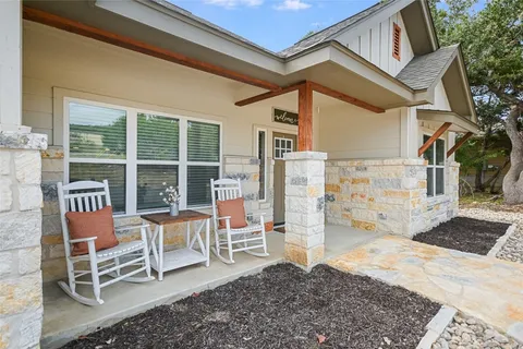 a living room with furniture kitchen view and a wooden floor