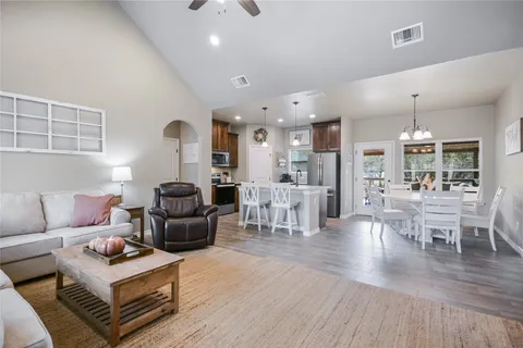 a view of a dining room and livingroom with furniture wooden floor a chandelier