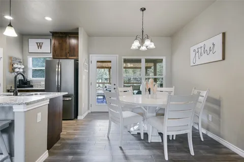 a kitchen with stainless steel appliances kitchen island granite countertop a dining table chairs and granite counter tops