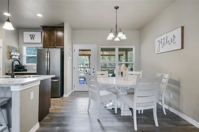 a kitchen with stainless steel appliances kitchen island granite countertop a dining table chairs and granite counter tops