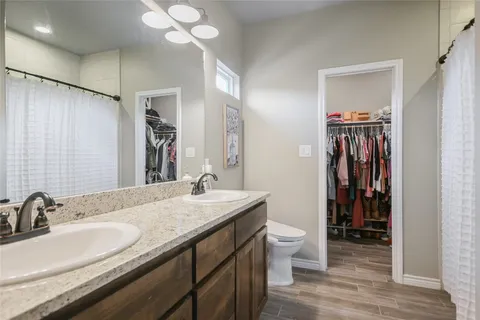 a en suite bathroom with a granite countertop sink and a mirror