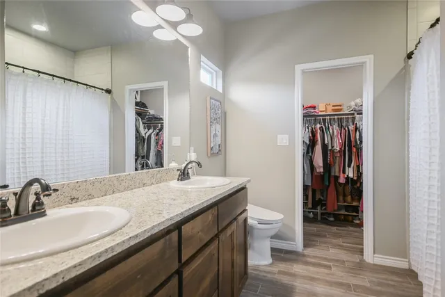a en suite bathroom with a granite countertop sink and a mirror