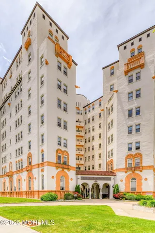 view of a tall building with a yard and plants