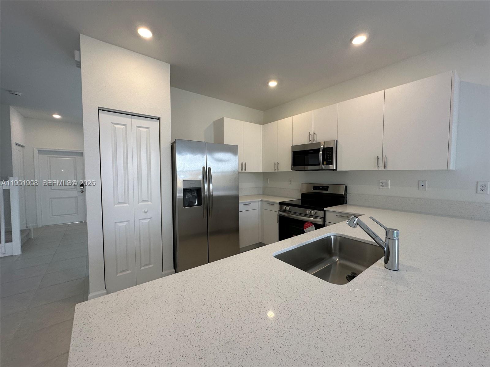 29229 Southwest 162nd Court Homestead, FL 33033 - Photo 5 of 27 a kitchen with granite countertop a refrigerator and a sink