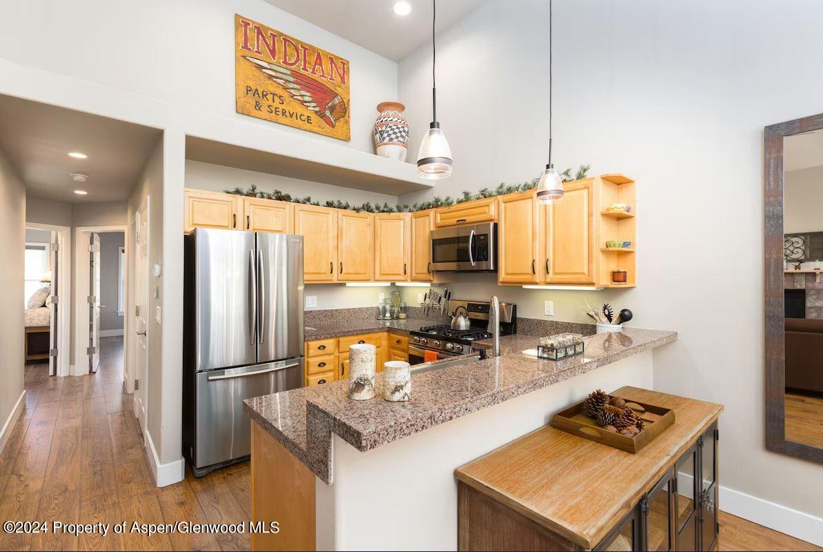 855 Gold Rivers Court, Unit 21D Basalt, CO 81621 - Photo 4 of 12 a kitchen with stainless steel appliances granite countertop a refrigerator a stove and a sink with wooden floor