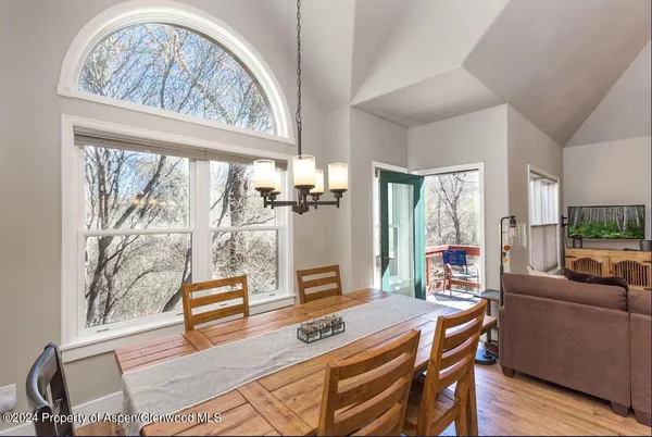 a dining room with furniture large windows and wooden floor