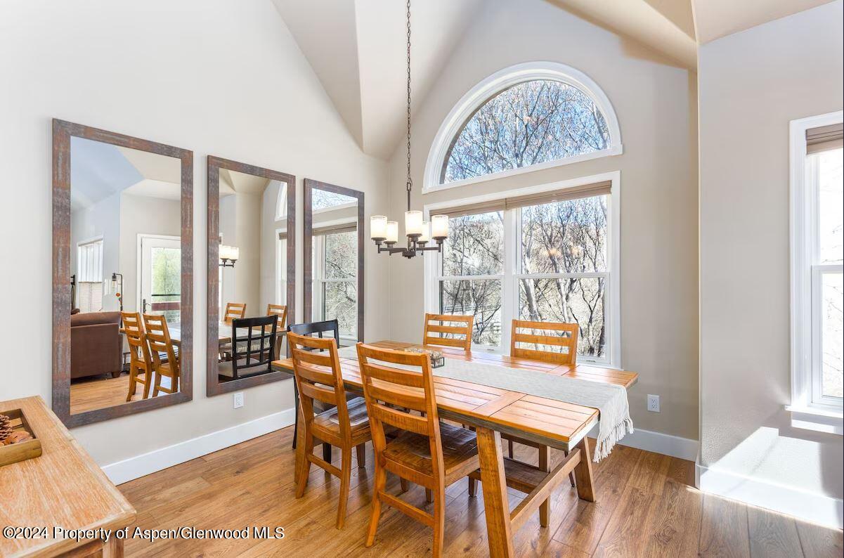 855 Gold Rivers Court, Unit 21D Basalt, CO 81621 - Photo 10 of 12 a dining room with furniture large windows and wooden floor