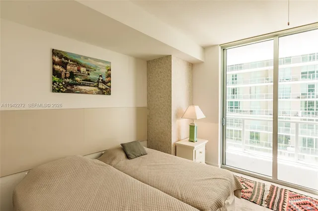 a bedroom with a bed and a large window