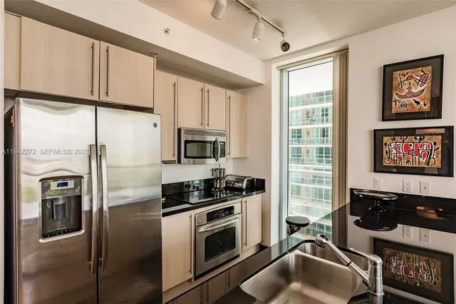 a kitchen with stainless steel appliances a refrigerator sink and stove