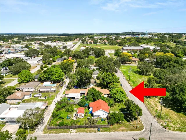 an aerial view of a house with a yard and large trees