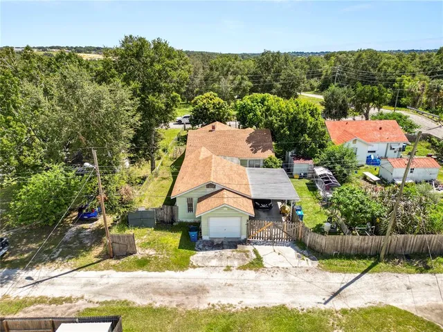 an aerial view of residential houses with outdoor space and trees