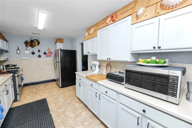 a kitchen with stainless steel appliances a sink dishwasher stove refrigerator and cabinets