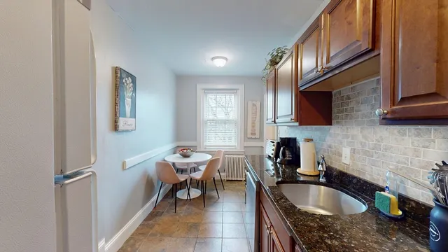 a kitchen with a sink a microwave cabinets and a dining table