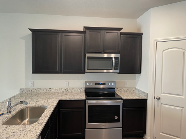 18741 Speculator Lane Elgin, TX 78621 - Photo 9 of 28 Kitchen with stainless steel appliances and light stone countertops