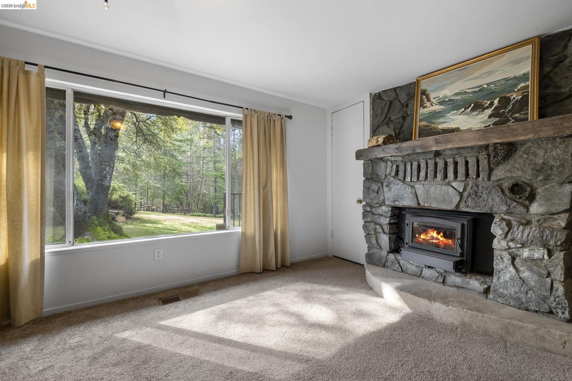 21550 Phoenix Lake Road Sonora, CA 95370 - Photo 20 of 50 a view of an empty room with window and fire place