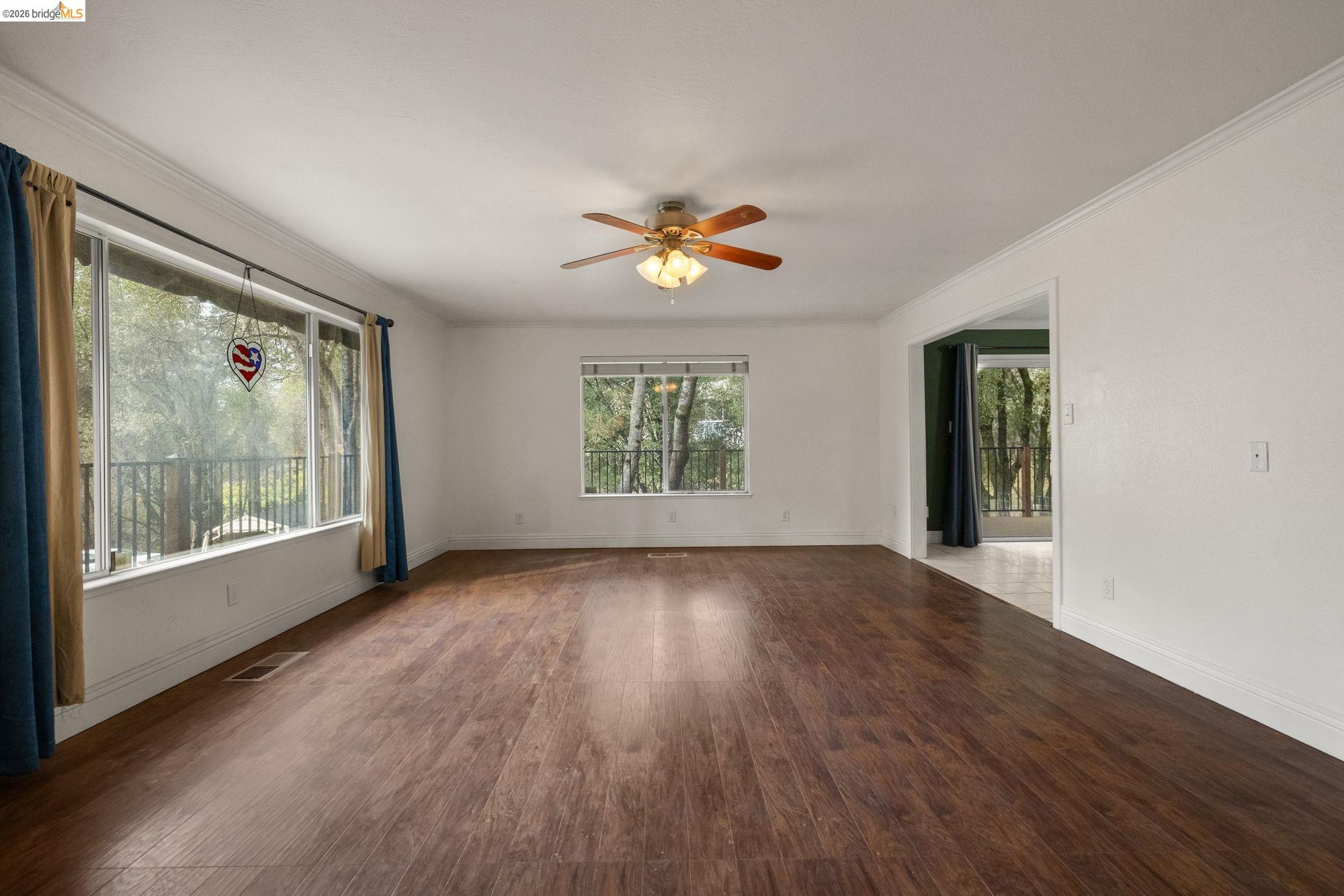 21550 Phoenix Lake Road Sonora, CA 95370 - Photo 2 of 50 a view of an empty room with a window and wooden floor